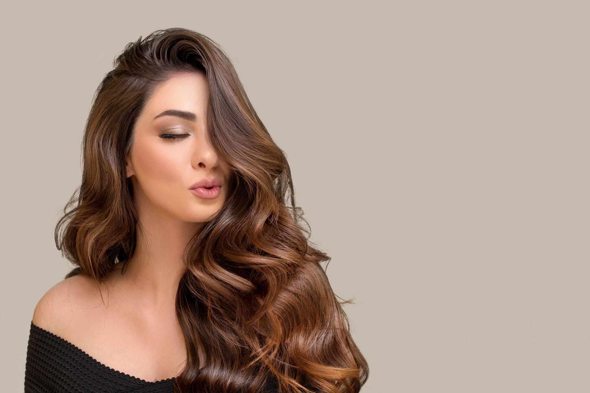 Frau mit voluminoesem, glaenzendem Haartraum und Haarstyling – idealer Look durch Haarteile