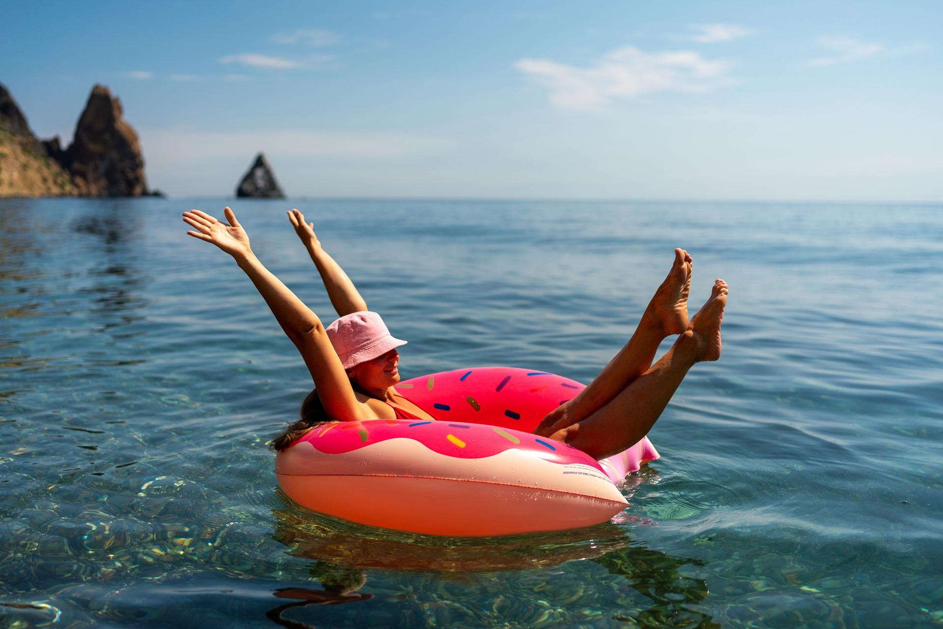 Frau entspannt auf Schwimmring im Meer | Escort München
